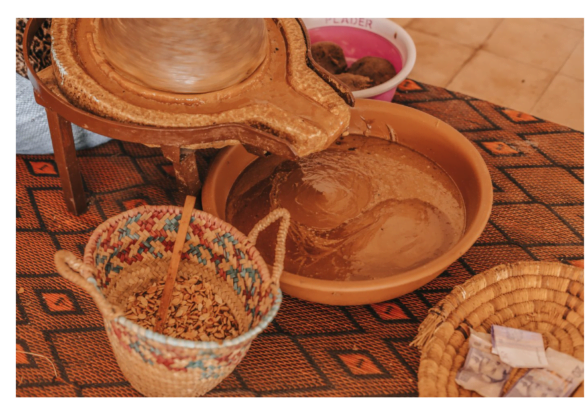 raditional production of argan oil, showing women cracking argan nuts and extracting the seeds, followed by grinding and pressing processes