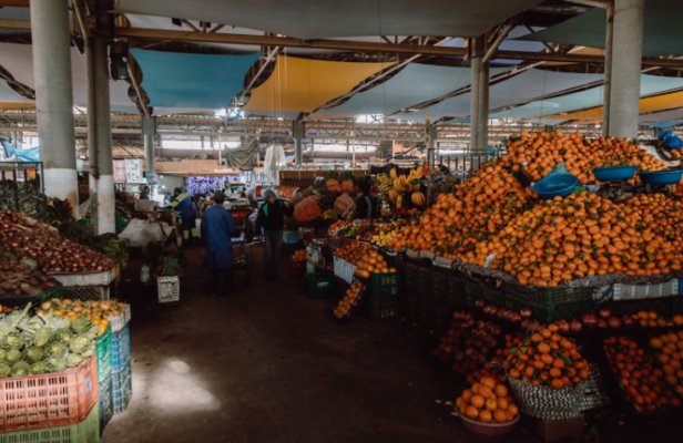 Souk El Had in Agadir, Morocco, bustling with vendors and shoppers amidst colorful stalls selling various goods, reflecting the vibrant atmosphere and cultural richness of the market.